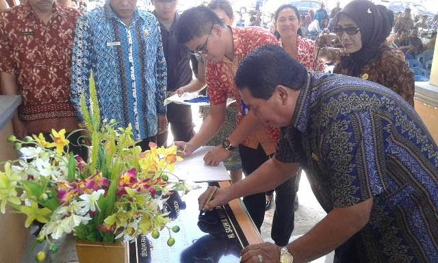 Bupati Bolmong Salihi Mokodongan saat menandatangani prasasti peresmian Kantor Camat Dumoga Tengah.