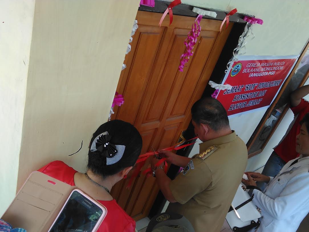 Bupati Bolmong Nixon Watung melakukan gunting pita tanda meresmikan bangunan Kantor BPMJ Sion Desa Pinogaluman Kecamatan Lolak.