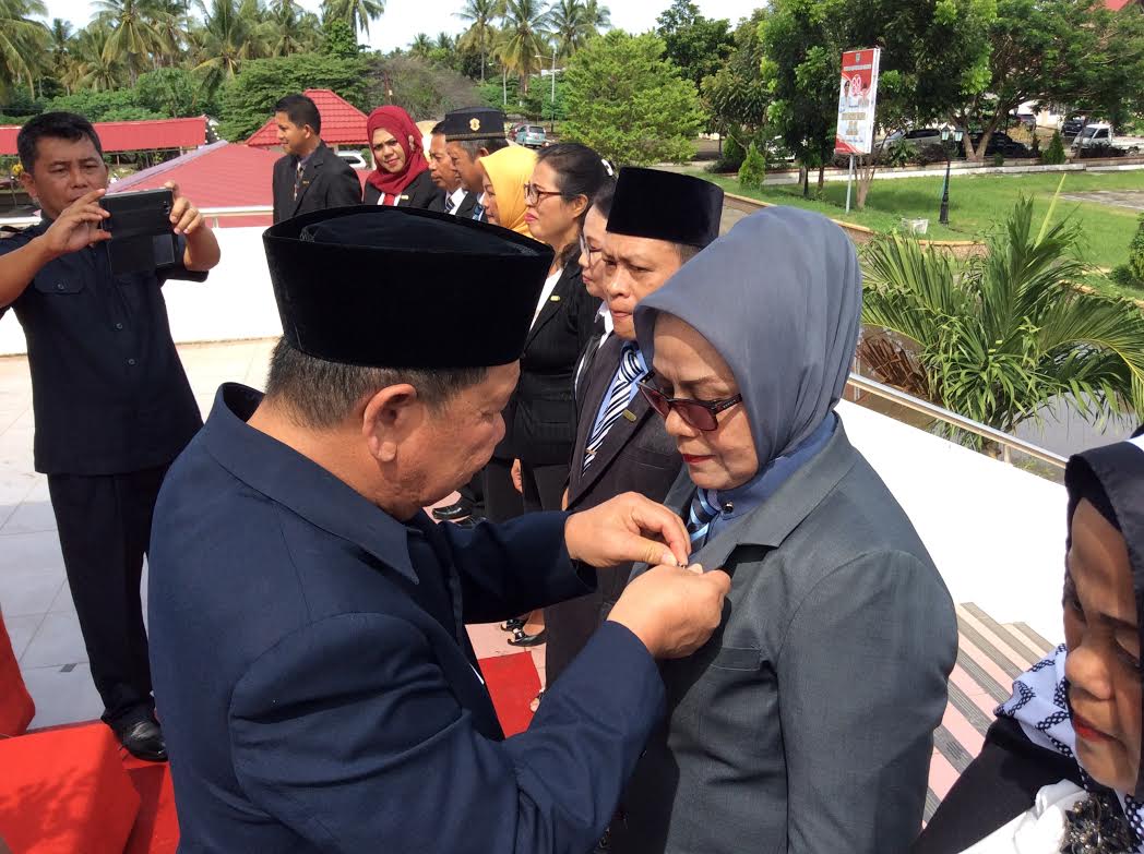 Bupati Bolmong Adrianus Watung menyematkan pin  tanda penghargaan kepada salah satu ASN Bolmong