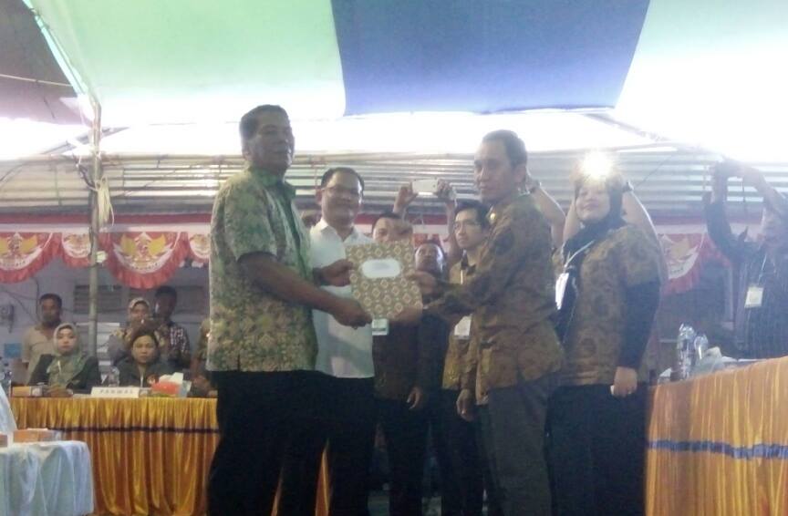 Ketua KPU Bolmong Fahmi Gobel saat menyerahkan dokumen penetapan pasangan calon kepada salah satu pasangan calon (dok : KPU BM)